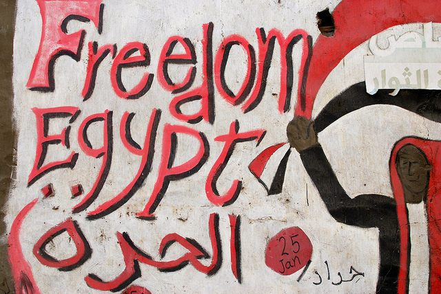 A black, red, and white mural reading "Freedom Egypt"