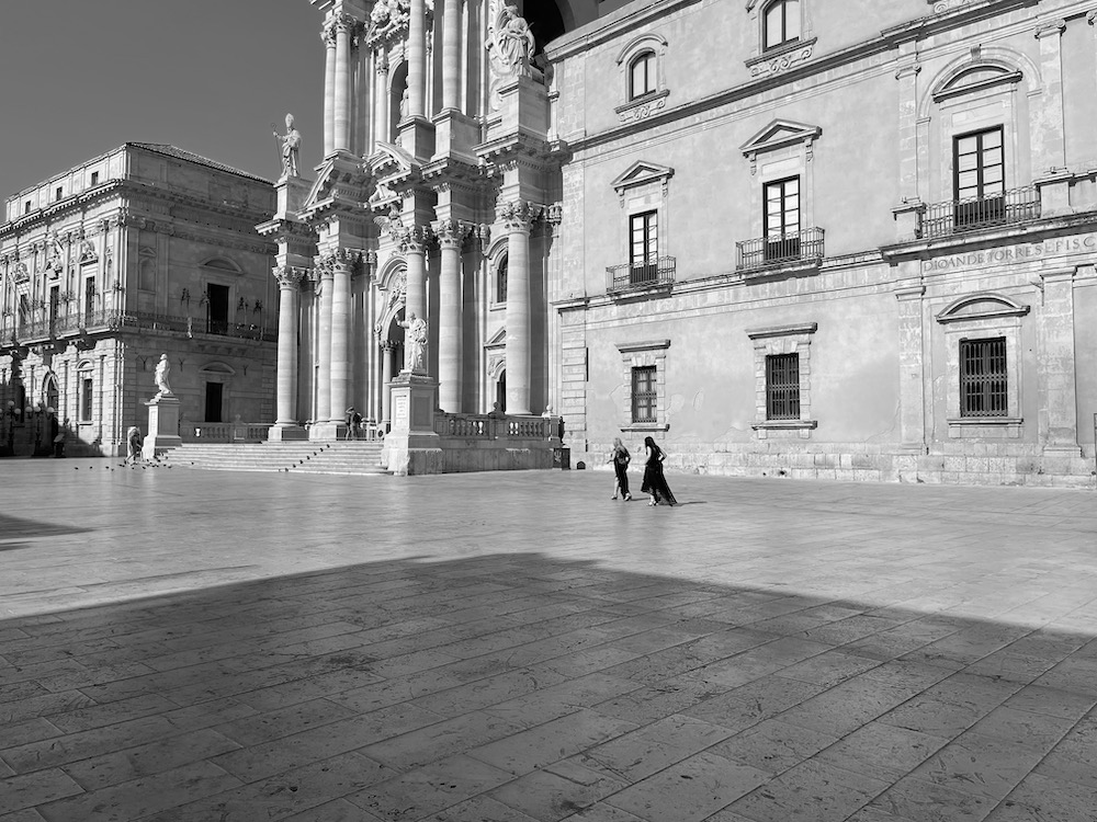 A plaza in Siracusa, empty except for two women